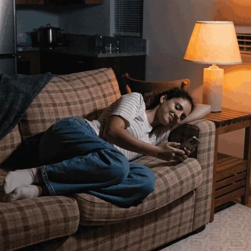 Paciente em casa à noite marcando consulta pelo celular